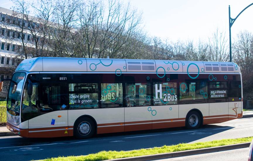 Zijaanzicht van de lijnbus van de MIVB die wordt aangedreven door waterstof (opschrift op de bus: H2bus)