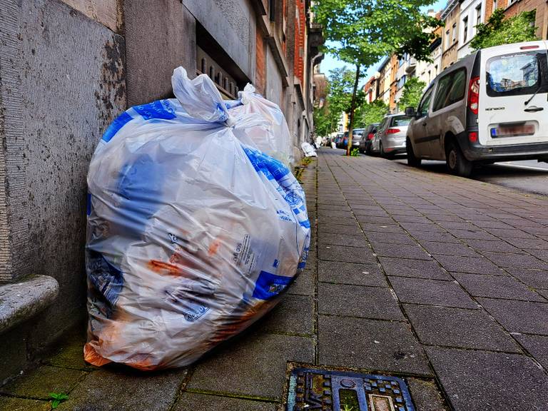 Huisvuilophaling door Net Brussel de witte zak met restafval, hier in Elsene
