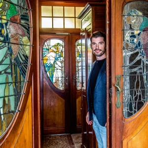 Gregory Van Aelbrouck bij de glas-in-lood-ramen in zijn woning van architect Fritz Seeldrayers uit 1900