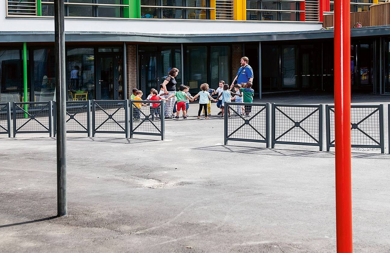 Tussen de speelplaats van de Franstaligen en die van de Nederlandstaligen staat een hek van tachtig centimeter hoog