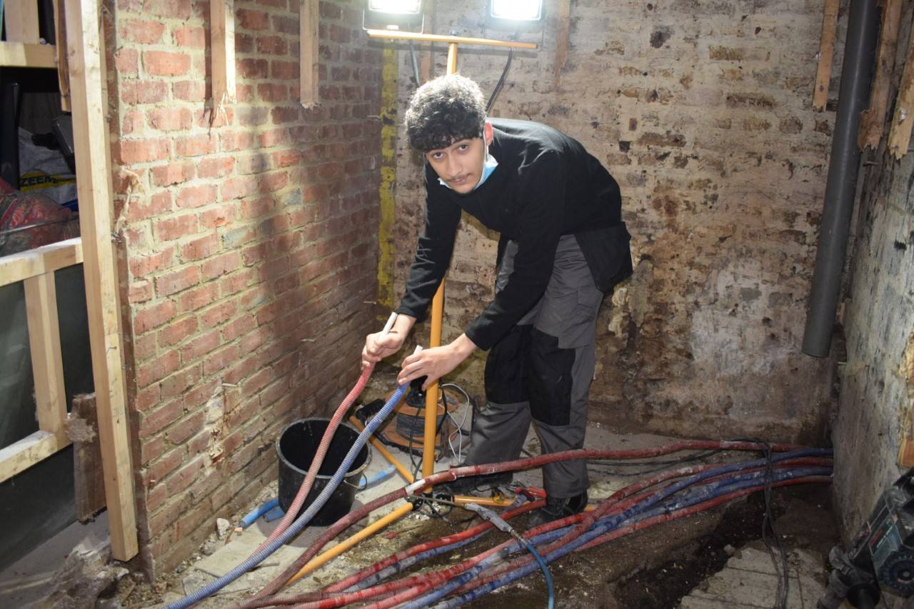 Een leerling van de Victor Hortaschool in Evere werkt aan waterleidingen in een gebouw