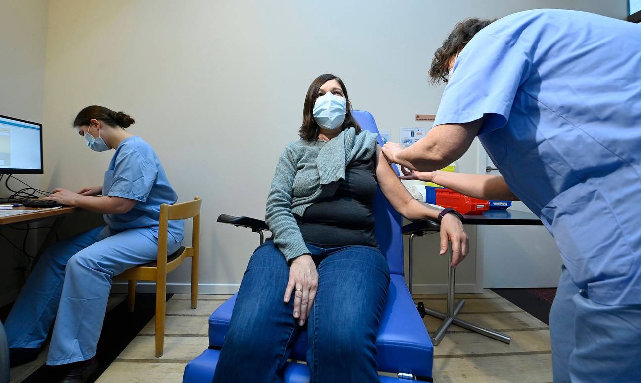 Een vrouw krijgt een corona-vaccin toegediend in het  vaccinatiecentrum Pacheco in Brussel-Stad