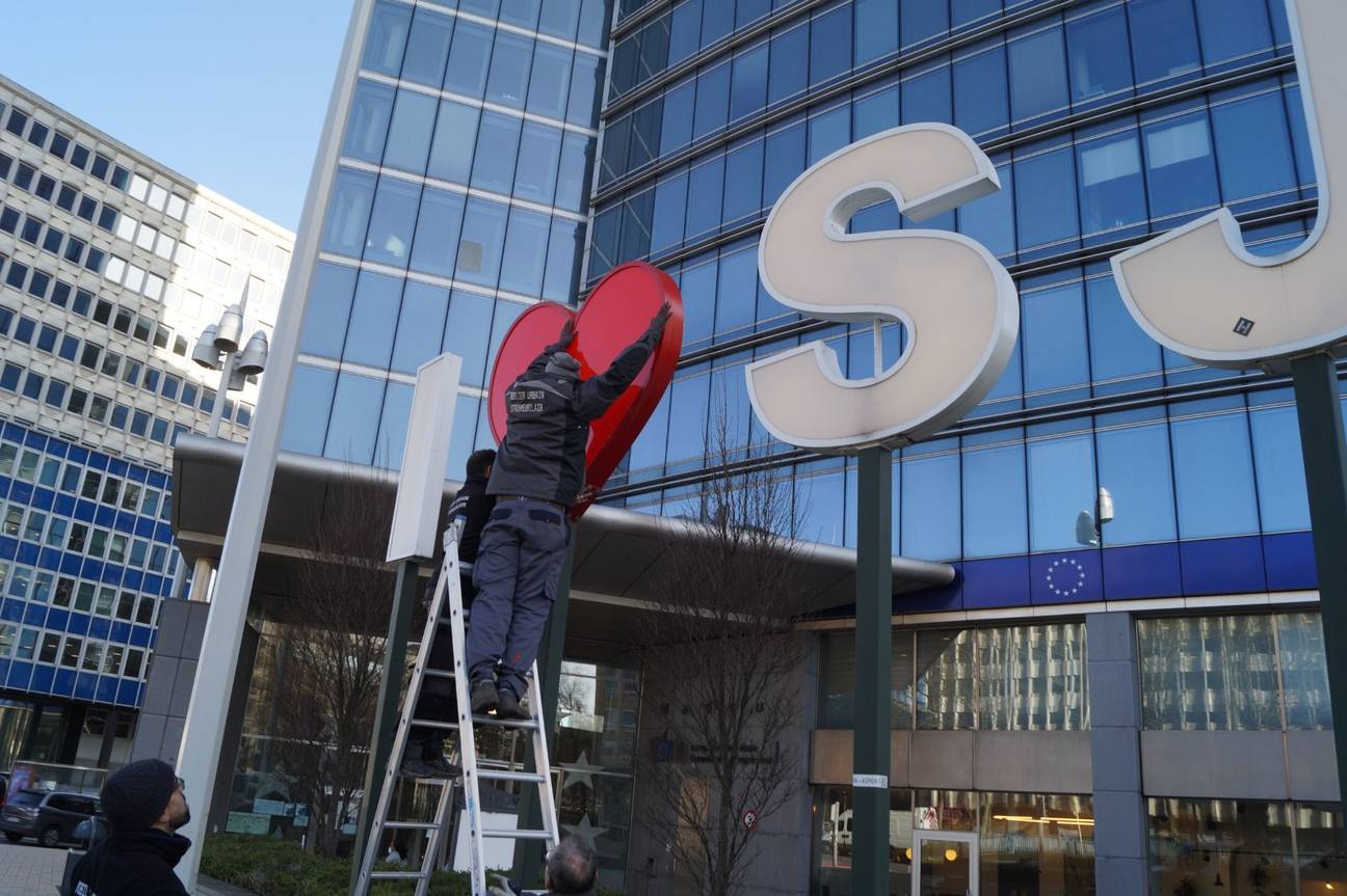 Een medewerker van de gemeente Sint-Joost-ten-Node hangt het hartje weer tussen de letters op het Madouplein