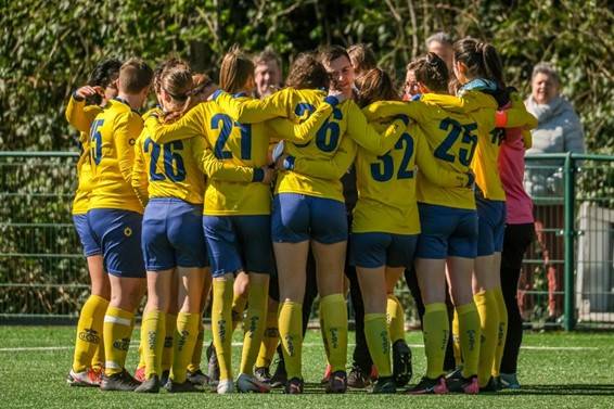 De vrouwen van RUSG Girls staan samen in een kring