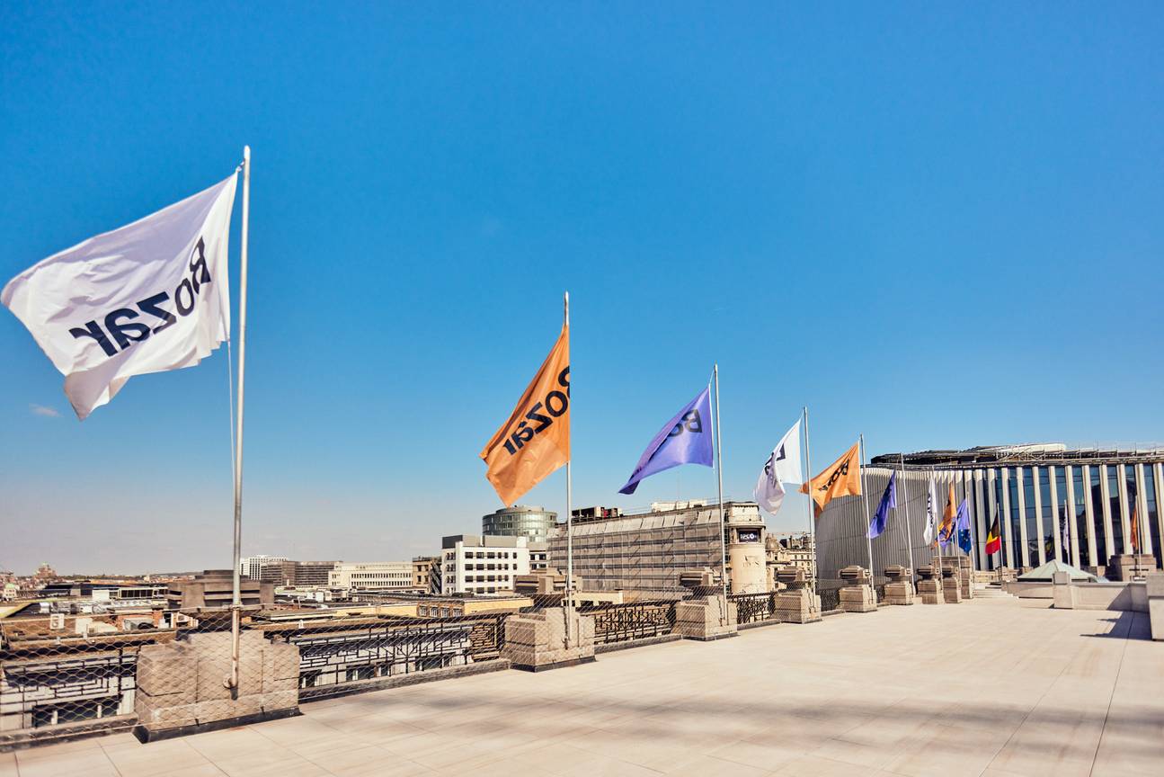 Het dakterras van Bozar met zicht op de stad, op de rand van het gebouw wapperen vlaggen