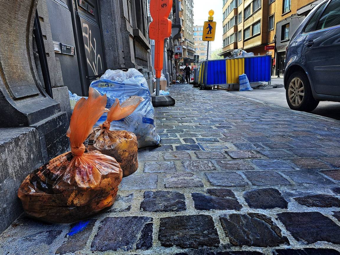 Huisvuilophaling door Net Brussel oranje en witte zak in de Vergniesstraat in Elsene