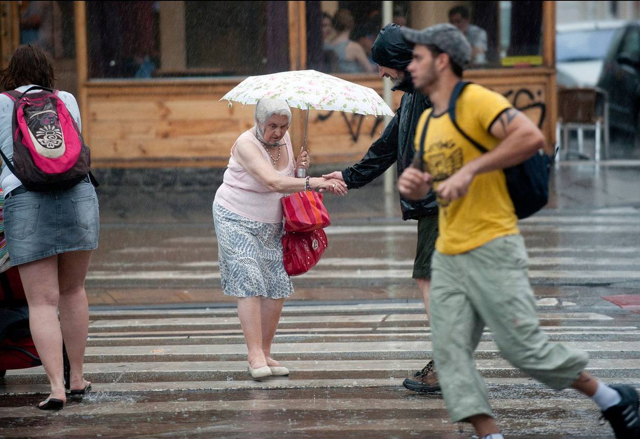 Onweer in Brussel regen paraplu Flageyplein oude vrouw bejaarden senioren
