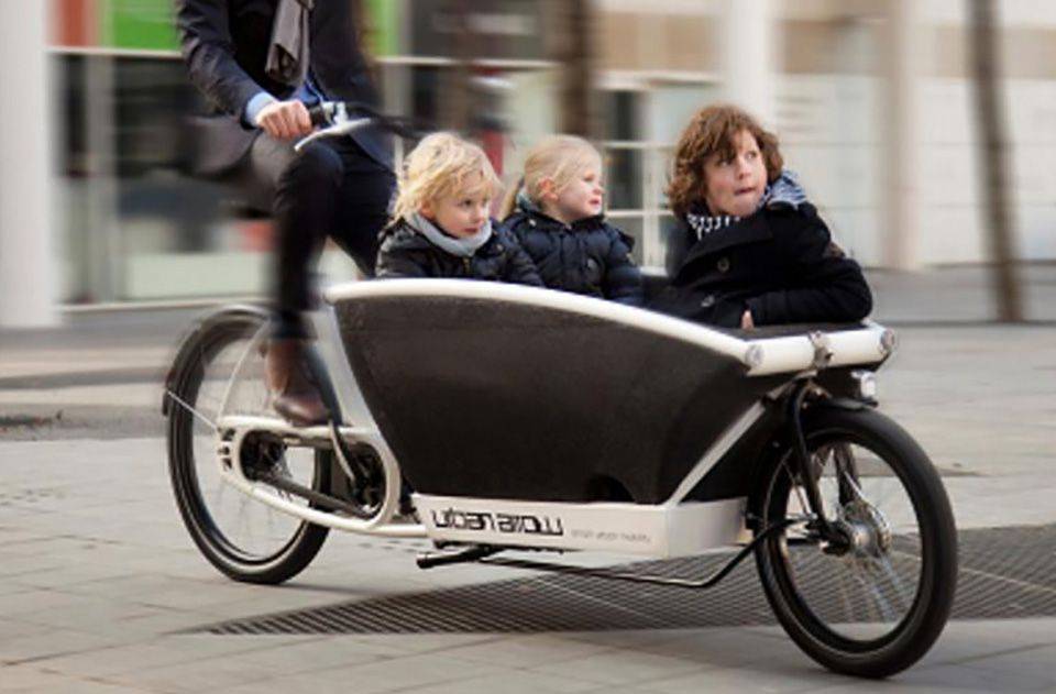 Drie kinderen me eop een Urban Arrow cargofiets
