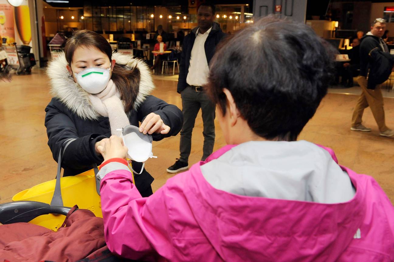 Een vlucht uit Beijing, net geland op Brussels Airport: personeel, douane en passagiers dragen mondmaskers als bescherming tegen het coronavirus