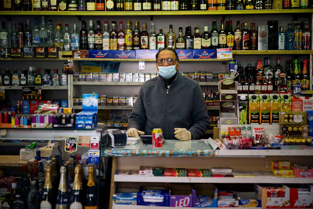 Nachtwinkel in Brussel tijdens de coronacrisis: de uitbater draagt een mondmasker om zichzelf (en eventueel anderen) te beschermen tegen het coronavirus en de ziekte corona-19
