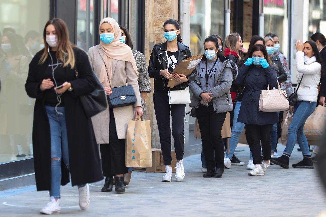 Een wachtrij van klanten met mondmasker in de Nieuwstraat