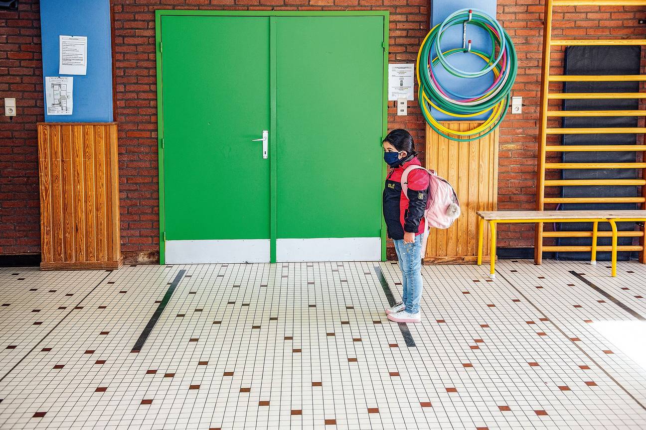 In basisschool De Mozaïek in Schaarbeek is in de gangen afgeplakt waar de kinderen moeten staan, ver genoeg uit elkaar