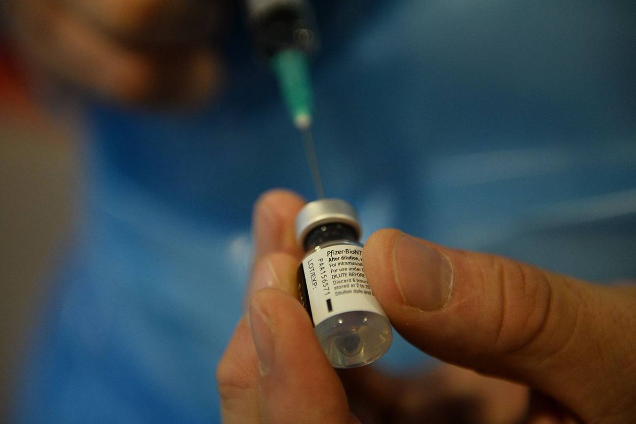 Een verpleger brengt alles in gereedheid voor een injectie met het vaccin tegen Covid-19 van Pfizer/BioNTech in het Brussels rusthuis Notre Dame de Stockel