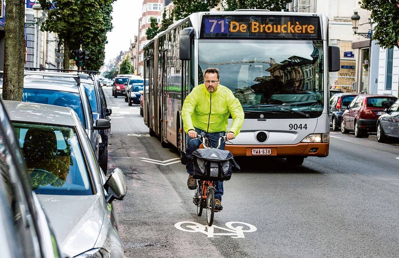 Een fietser deelt het verkeer met auto's en een MIVB)bus van Lijn 71 richting De Brouckère