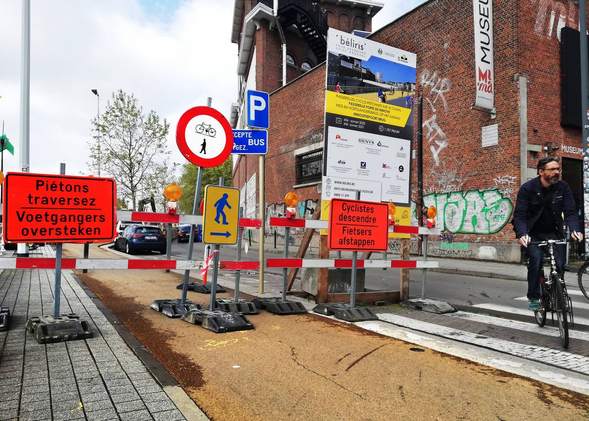 Mei 2021: het fietspad langs de Henegouwenkaai is tijdelijk afgesloten voor de aanleg van de fietsers- en voetgangersbrug over het kanaal ter hoogte van het Mima. Fietsers moeten afstappen en voetgangers moeten oversteken