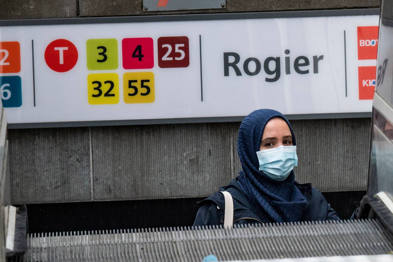 Een vrouw met hoofddoek verlaat metrostation Rogier