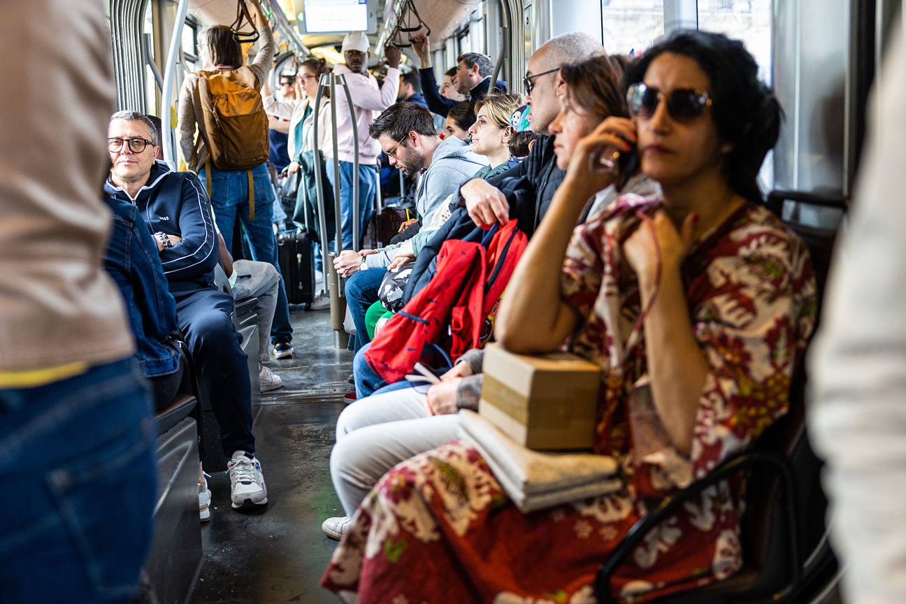 Een dame belt met haar smartphone op een tram van de MIVB