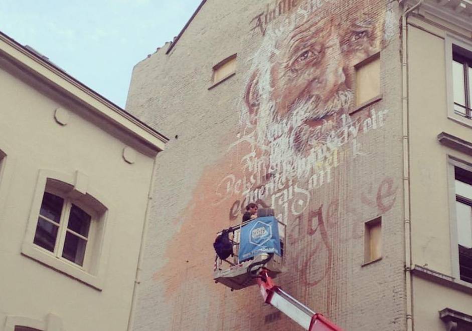 Een street artist aan het werk in de Naamsestraat