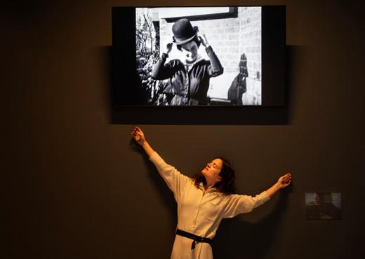 Charlotte Bouckaert onder een geprojecteerd filmpje van René en Georgette Magritte.