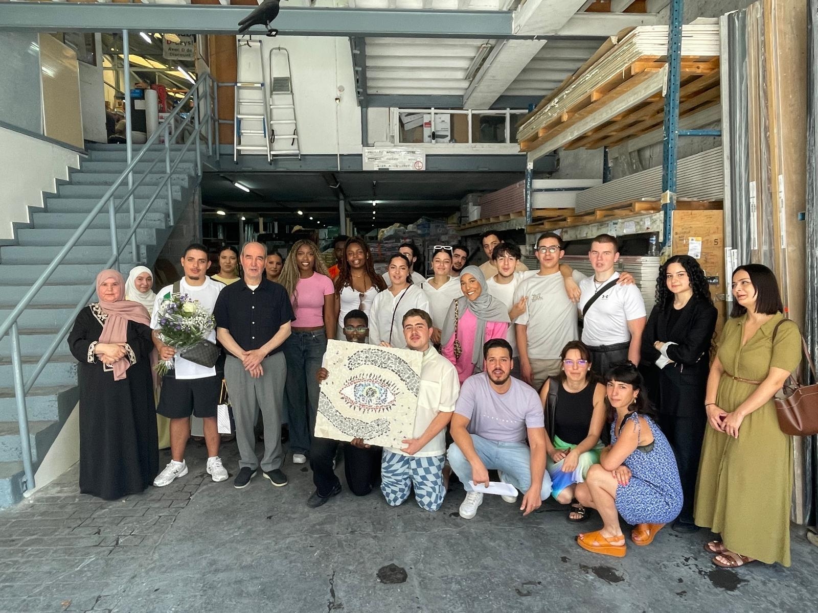 De jongeren van het collectief Ik ben België – Je suis la Belgique tonen het kunstwerk dat ze maakten met de brokstukken in Brico Ben in Molenbeek.