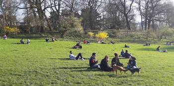 Groepjes mensen in de lentezon in het Park van Vorst