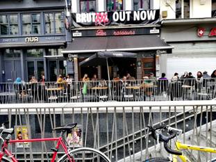 8 mei 2021: terrassen mogen opnieuw open onder voorwaarden. Op de foto Café Les Brasseurs op Anspachlaan zit vol, dankzij de parasols tegen de regen.