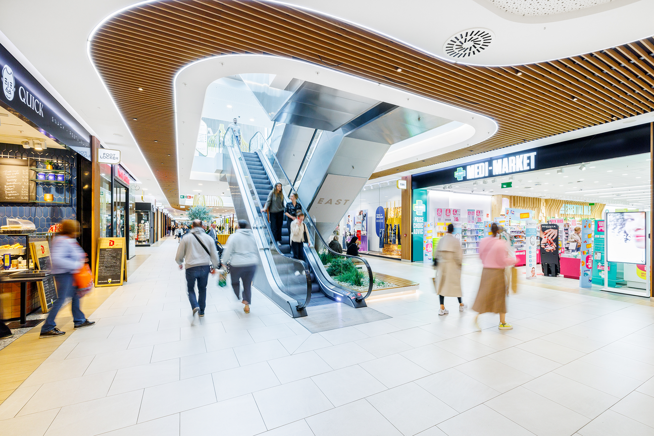 Het interieur van Westland Shopping Center met centraal een roltrap naar de volgende verdieping.