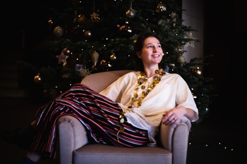 een kleurenfoto van margot otten bij de kerstboom