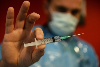 Een verpleger brengt alles in gereedheid voor een injectie met het vaccin tegen Covid-19 van Pfizer/BioNTech in het Brussels rusthuis Notre Dame de Stockel.
