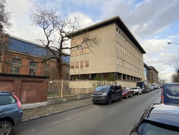 De gebouwen aan de straatkant in de Voltastraat, met in de achtergrond de grote centrale hal.