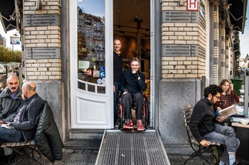 Geert Palmers en David Seffer in Café Winok in Schaarbeek, voorzien van een draagbare oprijplaat van Kinumai, de vzw die ze beiden oprichtten in 2020