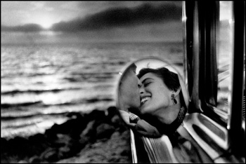 Elliott Erwitt; kussend koppel in hun wagen aan de Californische kust in 1955.