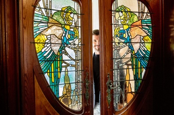 Gregory Van Aelbrouck bij de glas-in-lood-ramen in zijn woning van architect Fritz Seeldrayers uit 1900