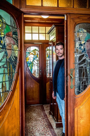 Gregory Van Aelbrouck bij de glas-in-lood-ramen in zijn woning van architect Fritz Seeldrayers uit 1900