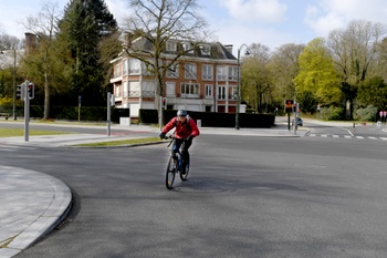 Fietser op een Franklin Rooseveltlaan zonder auto's, het gevolg van de regeringsmaatregelen tegen de verdere verspreiding van het coronavirus