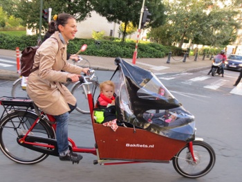 Een moeder vervoert haar kinderen door Brussel met een bakfiets