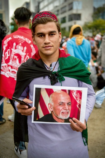 Ahmad woont sinds acht maanden in ons land.  Hij doet mee aan  het protest, met  een foto van Ashraf Ghani, de  gevluchte president van  Afghanistan.