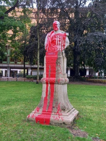 Monument met borstbeeld van Emile Storms, op de De Meeûssquare in Elsene, overgoten met rode verf