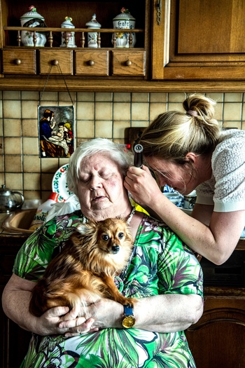 Huisdokter Marieke onderzoekt mevrouw Bosman in haar keuken tijdens een huisbezoek