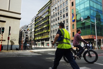 De groengevel van de Franse botanicus en groenkunstenaar Patrick Blanc in de Belliardstraat 14. Hier is vandaag het Federaal Planbureau gevestigd. Een arbeider in geel hesje van een werf vlakbij en een fietser passeren