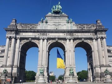 De Oekraïense vlag wappert in de middenste boog van de Triomfboog in het Jubelpark