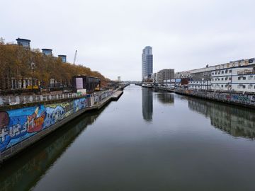 De aanleg van het toekomstige Bécopark aan de Materialenkaai en het Bécodok, gezien vanaf de brug aan het Saincteletteplein: de aanlegsteiger voor de waterbus is links te zien, achteraan de luxueuze woontoren Upsite, rechts de Akenkaai