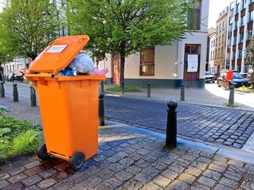 25 april 2023: een oranje container van Net Brussel voor voedingsafval, gevuld met PMD-afval in de Zennestraat, ter hoogte van de Slachthuisstraat. Vanaf 15 mei 2023 moeten alle inwoners van Brussel hun voedingsafval verplicht sorteren