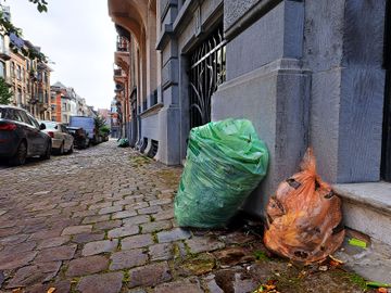 Huisvuilophaling door Net Brussel: de groene zak met tuinafval en de oranje zak met voedingsafval, hier in Elsene