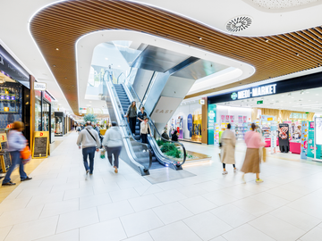 Het interieur van Westland Shopping Center met centraal een roltrap naar de volgende verdieping.