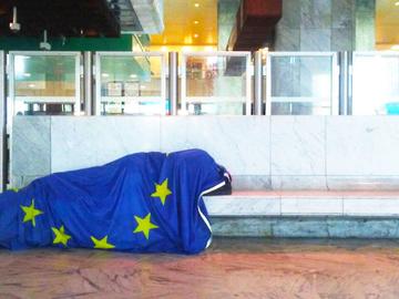 Dakloze in Noordstation met Europese vlag