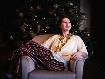 een kleurenfoto van margot otten bij de kerstboom