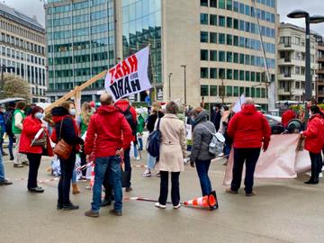 Een groepje actievoerders staat aan gebouwen van de Europese Unie aan het Schumanplein