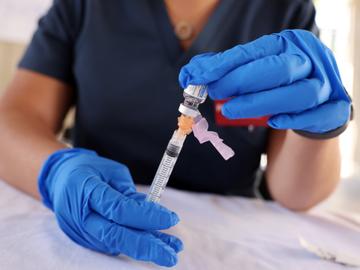 Iemand bereidt een spuit met het Janssen-vaccin voor