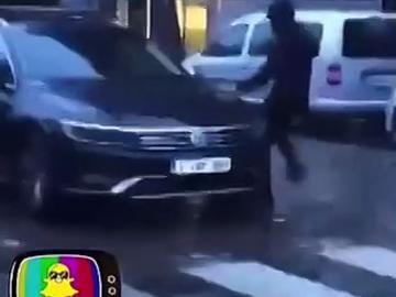 Screenshot uit filmpje op sociale media. Een man trapt tegen een geparkeerd politievoertuig